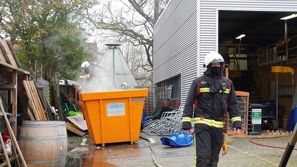 Brandweer blust bouwcontainer naast bedrijfspand in Assen