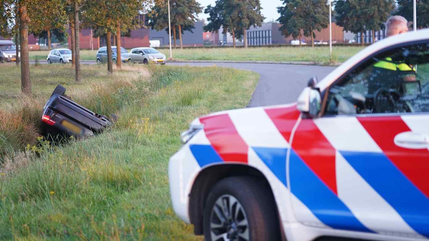 Auto op de kop in de sloot op bedrijventerrein Messchenveld